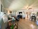 Comfortable living room with wood floors, a dining table, and a large entertainment center with a TV at 123 Pyracantha Ln, Leesburg, FL 34748