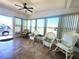 Bright sunroom featuring tiled floors, comfortable wicker furniture, and ample windows for natural light at 123 Pyracantha Ln, Leesburg, FL 34748