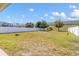 Spacious backyard featuring lush lawn, partial view of fence, and blue skies above at 1333 Darnaby Way, Orlando, FL 32824