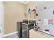 Modern laundry room featuring gray washer/dryer, overhead shelf, and utility equipment at 1333 Darnaby Way, Orlando, FL 32824