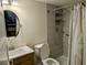 Bathroom with a round mirror, shower, tile walls, toilet, and updated vanity at 1640 Juno Trl # 101A, Astor, FL 32102