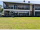 Two-story building exterior with screened balconies and a well-maintained lawn at 1640 Juno Trl # 101A, Astor, FL 32102