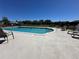 Community pool with clear blue water, surrounded by lounge chairs and a well-maintained deck at 1640 Juno Trl # 205B, Astor, FL 32102
