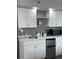Compact kitchenette with white cabinets and stainless steel refrigerator at 1909 S Atlantic Ave # 703, Daytona Beach, FL 32118
