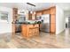 Kitchen featuring an island with seating, stainless steel appliances, and wood flooring at 1928 South Blvd, Maitland, FL 32751