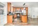 Kitchen featuring an island with seating, stainless steel appliances, and wood flooring at 1928 South Blvd, Maitland, FL 32751
