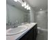 Bright bathroom with double sinks, gray countertops, and elegant tiled shower at 2117 Lincoln Ln, Bartow, FL 33830