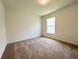 This bedroom has neutral carpet, a standard window, and is brightly lit with a ceiling mounted light at 2117 Lincoln Ln, Bartow, FL 33830