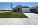 New single-story home with a two-car garage, manicured lawn, and decorative stone accents at 2117 Lincoln Ln, Bartow, FL 33830