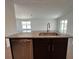 Kitchen island with stainless steel sink and dishwasher, granite countertop, and dark cabinets at 2117 Lincoln Ln, Bartow, FL 33830
