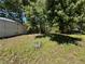 The backyard has mature trees and a storage shed at 24047 Ermine Rd, Astor, FL 32102
