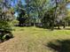 Large backyard with mature shade trees at 24047 Ermine Rd, Astor, FL 32102