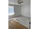 Bedroom with damaged tile flooring, ceiling fan, and natural light from the window at 24047 Ermine Rd, Astor, FL 32102