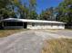 Charming single-story home with a metal roof and large front yard at 24047 Ermine Rd, Astor, FL 32102
