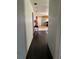 Long hallway leading to kitchen, featuring hardwood floors and outdated walls at 24047 Ermine Rd, Astor, FL 32102