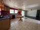 Spacious kitchen with wood cabinets, red accent wall, tile flooring and window views to the backyard at 24047 Ermine Rd, Astor, FL 32102