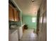Laundry room with turquoise walls, washer, dryer, sink, toilet and cabinet storage at 24047 Ermine Rd, Astor, FL 32102