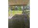 Covered wooden patio overlooking the backyard with a tree and grass at 24047 Ermine Rd, Astor, FL 32102