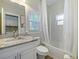 Well-lit bathroom featuring a shower with white tiles, a granite sink top, and modern fixtures at 302 W Park St, Lakeland, FL 33803