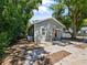 Well-maintained home featuring gray siding, a red door, and a concrete driveway surrounded by mature trees at 302 W Park St, Lakeland, FL 33803
