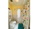 Bright bathroom with toilet, cabinet, and a colorful shower curtain at 334 Palo Verde Dr, Leesburg, FL 34748