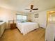 Comfortable bedroom with a ceiling fan, large window, and white wood floors at 334 Palo Verde Dr, Leesburg, FL 34748