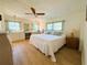 Bright bedroom features two windows, wooden ceiling fan, and elegant decor at 334 Palo Verde Dr, Leesburg, FL 34748