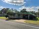 Charming home with covered parking, palm trees, and landscaped front yard at 334 Palo Verde Dr, Leesburg, FL 34748