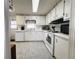 Charming kitchen with bright white cabinets, updated appliances, and tile flooring at 334 Palo Verde Dr, Leesburg, FL 34748