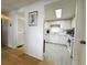 View from hallway into bright kitchen with white cabinetry and stainless appliances at 334 Palo Verde Dr, Leesburg, FL 34748