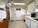 Bright kitchen with white cabinetry and stainless appliances, view toward door and refrigerator at 334 Palo Verde Dr, Leesburg, FL 34748
