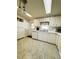 Bright kitchen with white cabinetry and stainless appliances, view toward door and refrigerator at 334 Palo Verde Dr, Leesburg, FL 34748