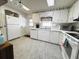 Charming kitchen with bright white cabinets, updated appliances, and tile flooring at 334 Palo Verde Dr, Leesburg, FL 34748