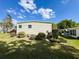 Landscaped side view of home with well-kept yard and tidy shrubbery at 334 Palo Verde Dr, Leesburg, FL 34748