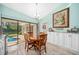 Bright dining area featuring a wooden table set, white cabinets, and sliding glass doors to the outdoor pool at 365 N Spaulding Cv, Lake Mary, FL 32746