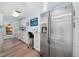 Well-organized laundry room with white cabinetry, stainless steel refrigerator, and built-in sewing station at 365 N Spaulding Cv, Lake Mary, FL 32746