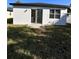 A backyard featuring a bright, white house, complete with sliding glass doors and a small concrete landing at 4420 W Gore Ave, Orlando,, FL 32811