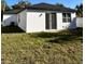 Bright shot of a backyard featuring a small house, a sliding glass door and sparse grass at 4420 W Gore Ave, Orlando,, FL 32811
