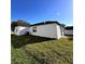 A backyard featuring a white house with a black roof, small windows and a small patch of grass at 4420 W Gore Ave, Orlando,, FL 32811