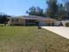 Charming ranch-style home featuring a well-maintained lawn, solar panels, and a quaint garden bed in front at 6832 Oswego Dr, Mount Dora, FL 32757