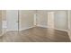Spacious bedroom featuring wood-look floors, white baseboards and trim, and natural light at 9324 Pecky Cypress Way, Orlando, FL 32836