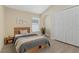 Cozy bedroom with a wooden bed frame, natural light, and an arched display shelf at 9324 Pecky Cypress Way, Orlando, FL 32836