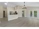 Open-concept living space and kitchen featuring white cabinets and stainless steel appliances at 9324 Pecky Cypress Way, Orlando, FL 32836
