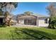 Backyard with a screened-in patio, green lawn, and landscaping creates a private outdoor oasis at 9651 Old Marsh Ct, Orlando, FL 32832