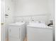 Functional laundry room featuring a washer, dryer, and overhead shelving at 9651 Old Marsh Ct, Orlando, FL 32832
