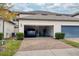 Two-car garage with blue car parked inside and brick paved driveway at 9790 Amber Chestnut Way, Winter Garden, FL 34787