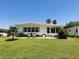 A relaxing outdoor living area with a patio, grill, seating, and a grassy lawn at 106 Palo Verde Dr, Leesburg, FL 34748