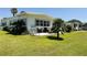 A sunny backyard with an outdoor patio, grill, and waterfront views at 106 Palo Verde Dr, Leesburg, FL 34748
