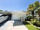 Cozy single-story home with carport, trimmed landscaping, and lush green lawn at 106 Palo Verde Dr, Leesburg, FL 34748