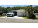 Charming single-story home with a well-manicured lawn, carport, and landscaped with a palm tree at 106 Palo Verde Dr, Leesburg, FL 34748